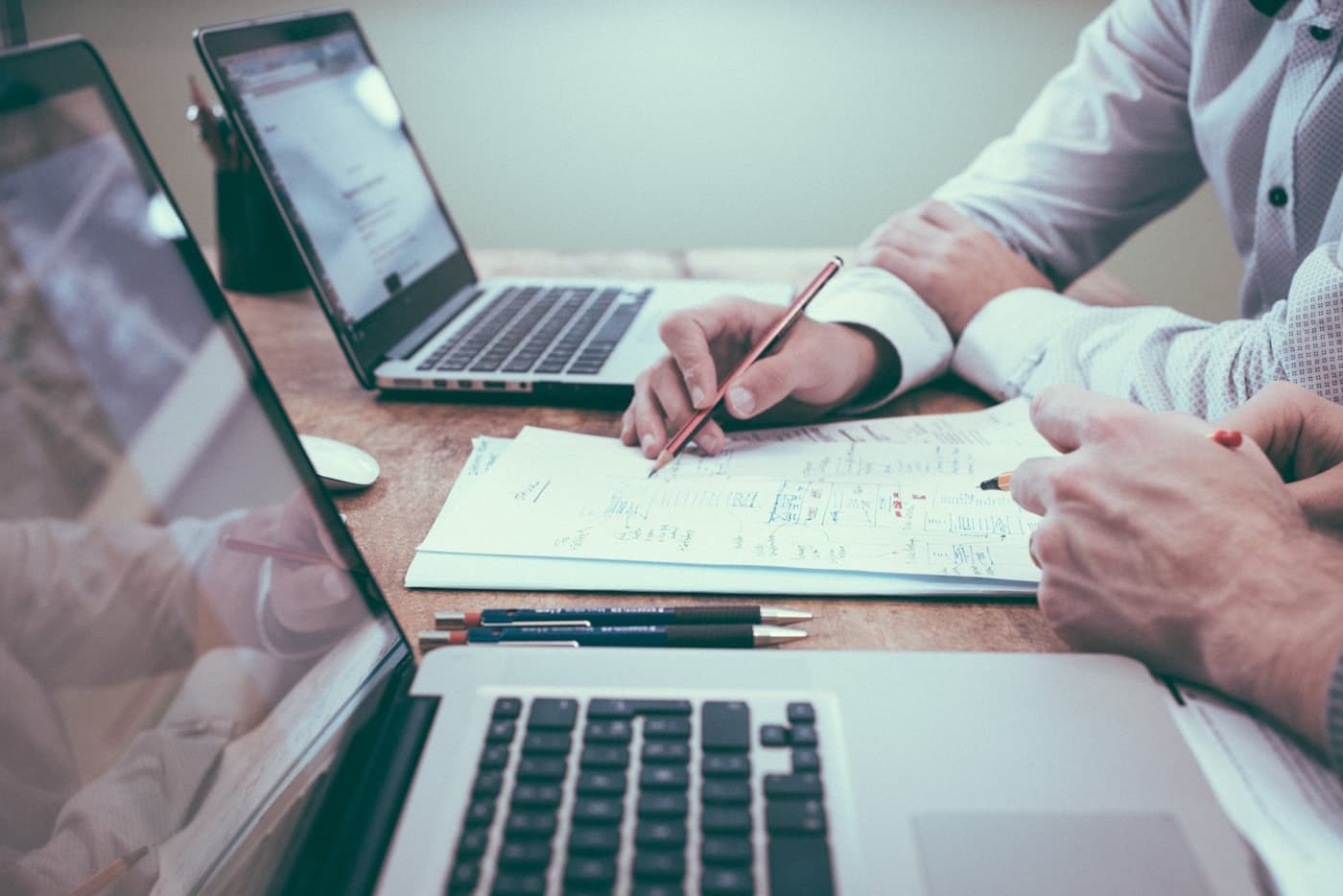 Des collaborateurs analysent un document devant leurs ordinateurs