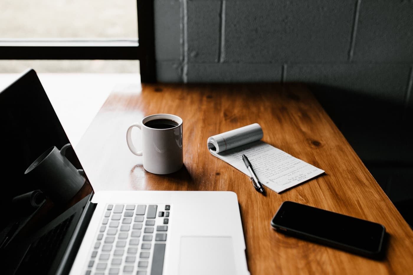 Un ordinateur, un téléphone et des notes prêts pour une session de travail