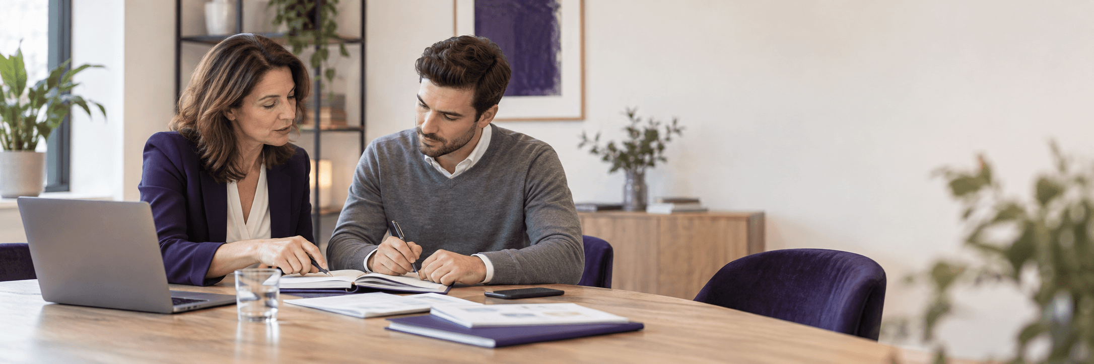 Une formatrice accompagne un commercial dans la préparation d’un rendez-vous, autour d’un carnet et d’un ordinateur.